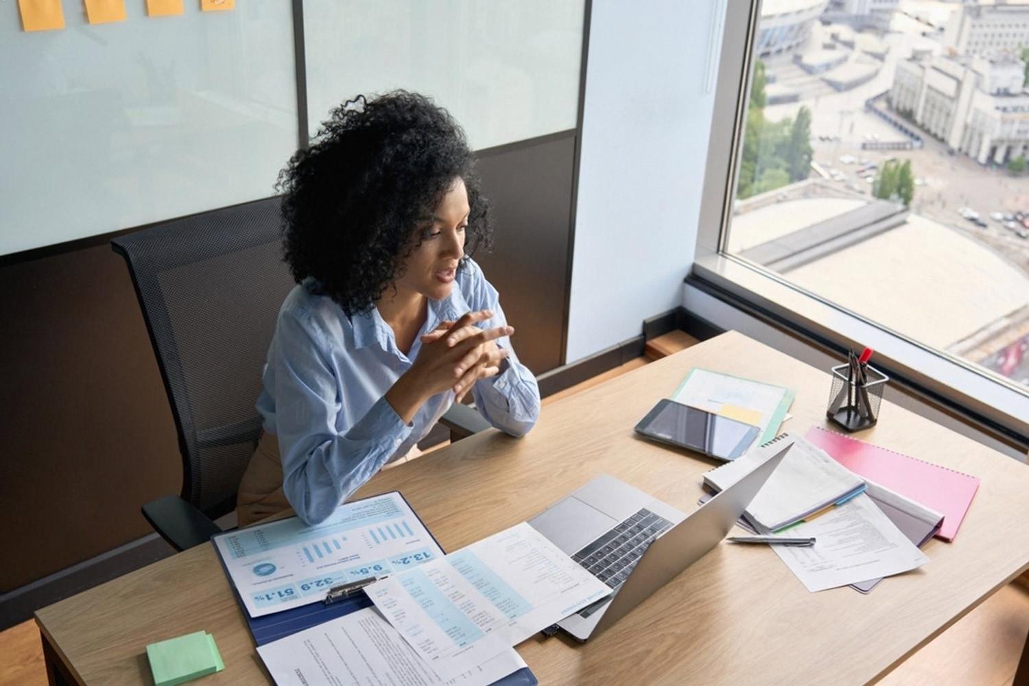 Analyst reviewing a company's financial report and online reputation in a UAE office
